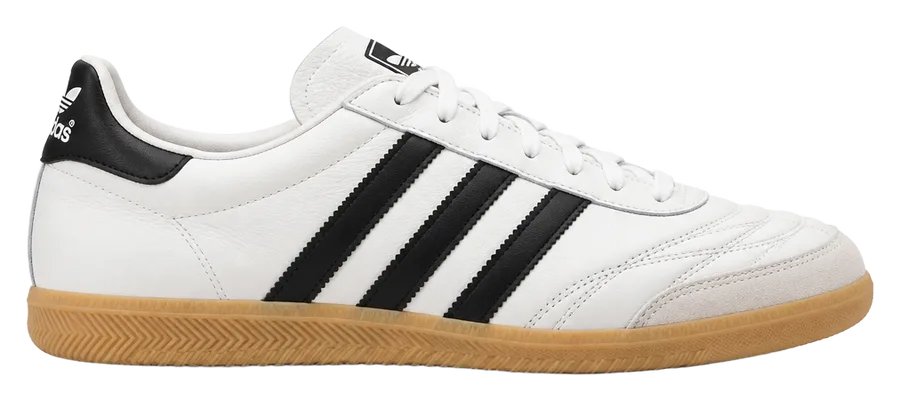White leather indoor soccer trainer with black stripes and a gum sole, side profile